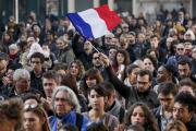 A man waves a French flag as several hundred people gather to observe a minute of silence in Lyon, France, Nov. 16 (CNS photo/Robert Pratta). 