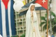 A statue of Mary is held above the crowd attending an outdoor Mass with Pope John Paul II during his 1998 visit to Cuba.