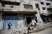 A Palestinian boy runs next to destroyed buildings in Gaza City Aug. 28. (CNS photo/Mohammed Saber, EPA) 