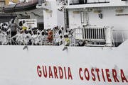 Migrants rescued from overcrowded boats near the Libyan coast stand on an Italian Coast Guard vessel on Feb. 14.