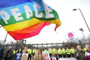 A woman waves a flag during a nuclear weapons protest April 13 outside Faslane Naval Base in Helensburgh, Scotland ( CNS photo/Joey Kelly, EPA).