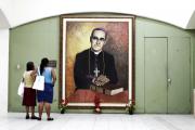 Salvadoran women look at a painting of slain Salvadoran Archbishop Oscar Romero at a cathedral in San Salvador.