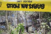 PEOPLE AS PROPERTY. A policeman makes his way through an abandoned human trafficking camp in northern Malaysia, May 2015.