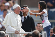 A young girl greets Pope Francis as he arrives in St. Peter's Square on Sept. 11