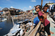 STORM WARNING. A girl reviews the devastated waterfront of Guiuan, Philippines, on Nov. 19. Did global warming contribute to the ferocity of Typhoon Haiyan?