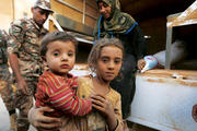 SAFE AT LAST? Syrian refugee children covered with dust arrive on Sept. 10 at the Jordanian border with Syria and Iraq, near Amman, Jordan. 