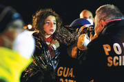 ￼A YOUNG SURVIVOR. Italian police photograph a child after migrants arrived by boat at the Sicilian harbor of Pozzallo on April 19, 2015.