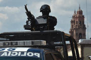 State of Siege: A federal police officer ready for action atop a vehicle in the Mexican state of Michoacan on Oct. 28