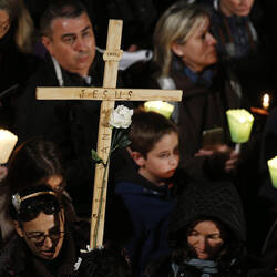 A woman holds a cross during the Way of the Cross presided at by Pope Francis outside the ancient Colosseum in Rome March 25. (CNS photo/Paul Haring)