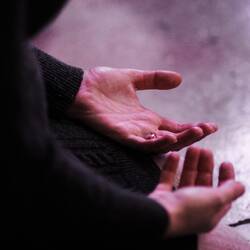two hands outstretched in prayer
