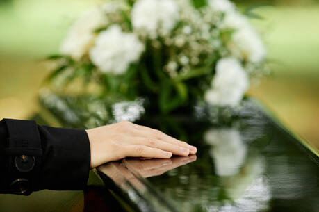 Close up of hand on coffin