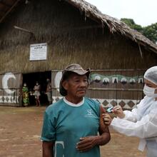 An Indigenous man receives the AstraZeneca/Oxford COVID-19 vaccine from a municipal health worker in the Sustainable Development Reserve of Tupe in Manaus, Brazil, Feb. 9, 2021. (CNS photo/Bruno Kelly, Reuters)