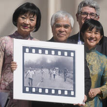 Nick Ut, center, flanked by UNESCO Ambassador Kim Phuc, left, holds “Napalm Girl,” his Pulitzer Prize-winning photo, as they wait to meet with Pope Francis Wednesday, May 11, 2022.