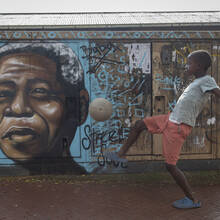 A child kicks a football in front of a mural of Nelson Mandela, in Soweto, South Africa, as the country celebrates Freedom Day on April 27. (AP Photo)