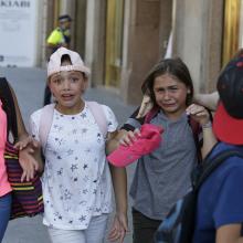 Children, some in tears, are escorted down a road in Barcelona, Spain, Thursday, Aug. 17, 2017. Police in Barcelona say a white van has mounted a sidewalk, struck several people in the city's Las Ramblas district. (AP Photo/Manu Fernandez)