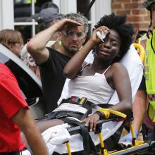 Rescue personnel help an injured woman after a car ran into a large group of protesters after an white nationalist rally in Charlottesville, Va., on Aug. 12. (AP Photo/Steve Helber) Rescue personnel help an injured woman after a car ran into a large group of protesters after an white nationalist rally in Charlottesville, Va., on Aug. 12. (AP Photo/Steve Helber)