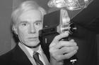 Artist and underground filmmaker Andy Warhol poses with one of Polaroid's new film cameras, the Polavision camera, which features instant replay on television screens, Feb. 1, 1978. (AP Photo/Dave Pickoff)