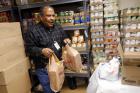 Volunteer carries bags of food for Emergency Assistance Department at Chicago Catholic Charities (CNS photo/Jim Young, Reuters)