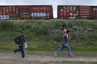 A Salvadoran father carries his son while running in Huehuetoca, Mexico, in June 2015 as they try to board a train heading to the U.S-Mexico border. (CNS photo/Edgard Garrido, Reuters)