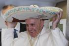 Pope Francis tries on a sombrero while meeting journalists aboard his flight to Havana on Feb. 12. (CNS photo/Paul Haring)