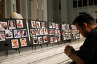 A man prays on June 15, 2016, in front of photographs of victims of the mass shooting at an L.G.B.T. nightclub in Orlando, Fla., during a vigil at a nearby church. The mass shooting was one of the hate crimes discussed on July 16 at a hearing held by the Helsinki Commission. (CNS photo/Jim Young, Reuters) 