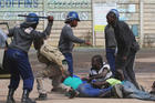 Riot police detain residents after a July 4 protest by taxi drivers turned violent in Harare, Zimbabwe. Violent protests in Zimbabwe reflect people's frustrations in extremely difficult times, a church official said. (CNS photo/Philimon Bulawayo, Reuters)