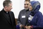 Chicago Archbishop Blase J. Cupich visits with a couple during a June 27 Catholic-Muslim dinner in Bridgeview, Ill. (CNS photo/Karen Callaway/Catholic New World)