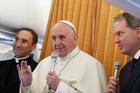 Pope Francis answers questions from journalists aboard his flight from Malmo, Sweden, to Rome Nov. 1. At left is Father Mauricio Rueda Beltz, papal trip planner; at right is Greg Burke, Vatican spokesman.(CNS photo/Paul Haring)