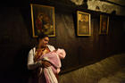 A pilgrim from India holds her baby in front of a painting of the Mary and the Christ Child in the grotto of the Church of Nativity in Bethlehem. (CNS photo/Debbie Hill)