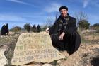 Bishop Oscar Cantu of Las Cruces, N.M., kneels by a stone that reads "We Refuse To Be Enemies" Jan. 16 at the entrance to the Tent of Nations in the West Bank, near Bethlehem. (CNS photo/Debbie Hill)