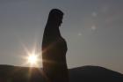 The sun sets behind a statue of Mary on Apparition Hill in Medjugorje, Bosnia-Herzegovina. (CNS photo/Paul Haring)