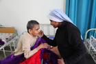 A religious sister is seen comforting a sick woman in 2016 at Snehadam Old Age Home in Gurgaon, India. Catholic Near East Welfare Association is celebrating 90 years of service to Eastern Catholic churches and the poor in the Middle East, northeast Africa, India and Eastern Europe. (CNS photo/courtesy John E. Kozar, CNEWA)