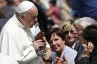 Pope Francis kisses a Marian statue presented by someone in the crowd during his general audience in St. Peter's Square at the Vatican on April 5. (CNS photo/Paul Haring)