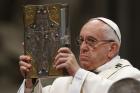 Pope Francis raises the Book of the Gospels as he celebrates Holy Thursday chrism Mass in St. Peter’s Basilica at the Vatican April 13. 