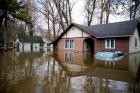 A car is seen submerged in front of a home on May 9 in the flooded Montreal suburb of Pierrefonds, Quebec. A mix of heavy rains and melting snow caused the situation. (CNS photo/Christinne Muschi, Reuters)