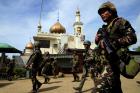 Philippine government soldiers walk past a mosque before their May 25 assault on Maute insurgents, who have taken over large parts of the town of Marawi. Residents started to evacuate Marawi after President Rodrigo Duterte imposed martial law across the entire Muslim-majority region of Mindanao. (CNS photo/Romeo Ranoco, Reuters)