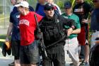 A U.S. Capitol police SWAT team officer escorts members of Congress and congressional staff from the scene after a gunman opened fire on Republican members of Congress during a baseball practice in Alexandria, Va., on June 14. (CNS photo/Joshua Roberts, Reuters)