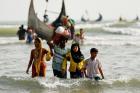 Rohingya refugees walk to shore in Teknaf, Bangladesh, with their belongings after crossing the Bangladesh-Myanmar border through the Bay of Bengal on Sept. 5. (CNS photo/Mohammad Ponir Hossain, Reuters)