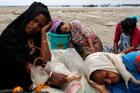 Exhausted Rohingya refugees rest on the shore in Shah Porir Dwip, Bangladesh, after crossing by boat through the Bay of Bengal on Sept. 10. (CNS photo/Danish Siddiqui, Reuters)