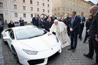 Pope Francis autographs a Lamborghini presented by representatives of the Italian automaker at the Vatican on Nov. 15. The car will be a auctioned and the proceeds given to charity. (CNS photo/L'Osservatore Romano)
