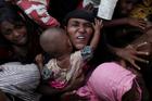 A Rohingya woman holds her infant as she scuffles to receive relief aid Nov. 28 in the Kutupalong refugee camp near Cox's Bazar, Bangladesh. (CNS photo/Susana Vera, Reuters)