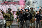 Israeli forces fire toward Palestinians near Ramallah, West Bank, during a Dec. 20 protest against U.S. President Donald Trump's decision to recognize Jerusalem as the capital of Israel. (CNS photo/Mussa Qawasma Reuters)