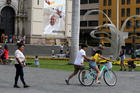 People walk near a banner with an image of Pope Francis on the facade of the cathedral in Lima, Peru, on Jan. 3. On Jan. 15, Pope Francis will begin a six-day visit to Chile and Peru. (CNS photo/Mariana Bazo, Reuters)