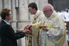 Cardinal Rainer Maria Woelki of Cologne, Germany, and Cardinal Reinhard Marx of Munich and Freising distribute Communion during Cardinal Woelki's installation Mass at the cathedral in Cologne on Sept. 20, 2014. (CNS photo/Jorg Loeffke, KNA) 