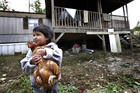 A boy holds a family chicken outside his home in Steele, Ala., in this 2013 file photo. (CNS photo/Karen Callaway, Catholic New World) 