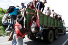 Honduran migrants climb on a truck Oct. 23 in Chiquimula, Guatemala, as they travel with other Central Americans in a caravan heading to the United States. (CNS photo/Luis Echeverria, Reuters)