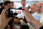 A journalist takes a cell phone photo of Pope Francis Jan. 23, 2019, aboard his flight from Rome to Panama for World Youth Day. (CNS photo/Vatican Media)