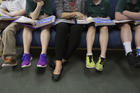 A teacher at Holy Name of Jesus Catholic School in Henderson, Ky., helps third-grade students with a reading lesson on March 28, 2019. A new document from the Vatican Congregation on Education states that Catholic schools and parents must help teach children that gender is fixed from birth. (CNS photo/Tyler Orsburn)