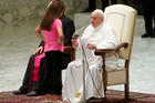 A girl talks with Pope Francis during his general audience in Paul VI hall at the Vatican Aug. 21, 2019. The pope allowed the girl with an undisclosed illness to move around undisturbed clapping and dancing on the stage.