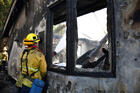 A firefighter douses water on a house after it was burned by the wind-driven Getty Fire outside Los Angeles Oct. 28, 2019. By Oct. 29, the fire had burned more than 600 acres and was 5% contained, according to the Los Angeles Fire Department. (CNS photo/Gene Blevins, Reuters) 